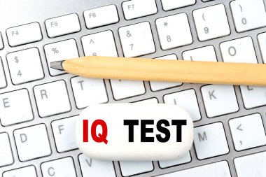 Klavyede kalem olan bir silgi üzerindeki IQ testi metni