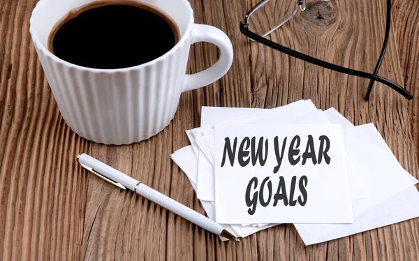 stock image NEW YEARS GOALS text on a sticky with coffee and pen on wooden background