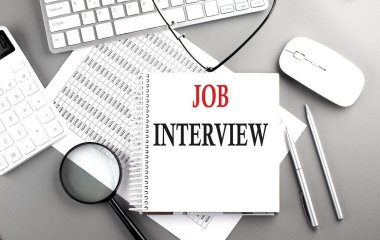 Not defteri üzerinde Gri bir arkaplan üzerinde klavye ve hesap makinesi ile JoB Röportaj metni