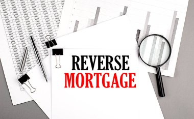 REVERSE MORTGAGE text on paper on a chart background clipart