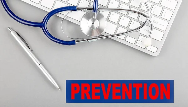 stock image PREVENTION word with Stethoscope on a keyboard on grey background