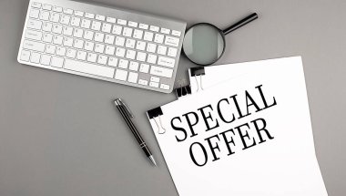 Üzerinde klavye, büyüteç ve kalem olan bir kağıt üzerinde özel teklif metni. İş konsepti