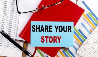 SHARE YOUR STORY text on a sticky on red notebook on chart background clipart