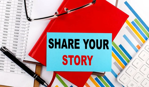 stock image SHARE YOUR STORY text on a sticky on red notebook on chart background