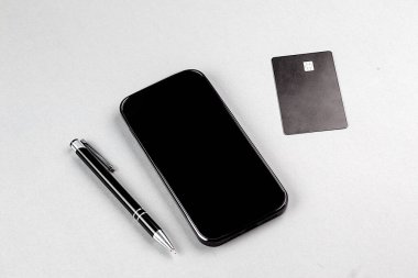 İnternetten alışveriş konsepti. Gri arka planda kredi kartı olan akıllı bir telefon.