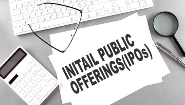 Klavyeli bir kağıt üzerinde ilk kamu hizmeti metni, gri arkaplan üzerinde hesap makinesi