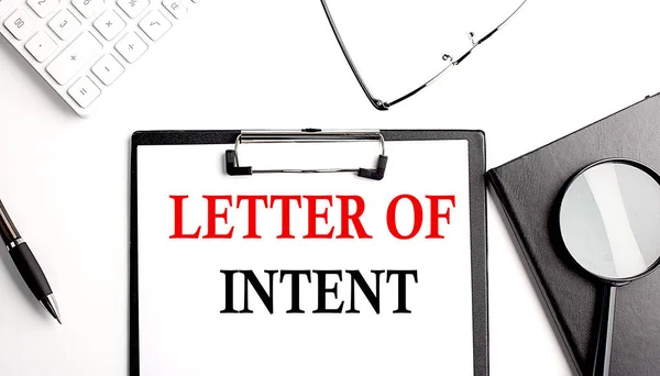 LETTER OF INTENT text written on a paper clipboard with office tools
