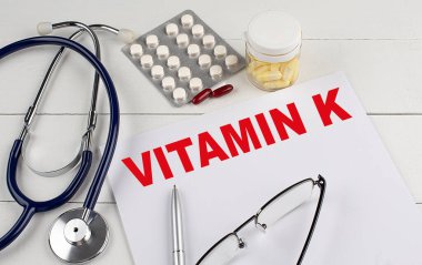 VITAMIN K kelime steteskop ve haplar ile bir kağıt üzerinde