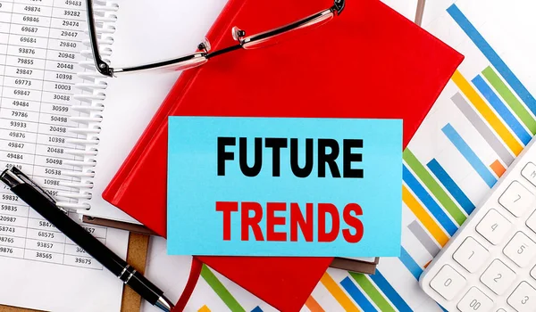 FUTURE TRENDS text on a sticky on red notebook on chart background