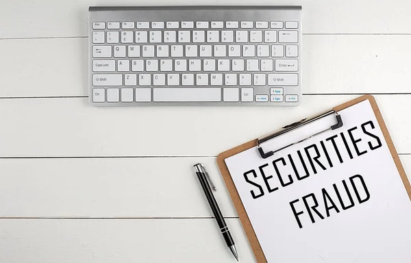 Beyaz ahşap bir arka plan, iş konsepti üzerinde SECURITIES FRAUD metin ile ev ofis çalışma alanı, klavye, pano ve kalem