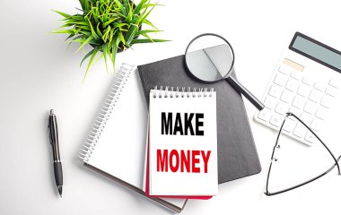 Beyaz arkaplanda ofis araçları olan bir dizüstü bilgisayardan para kazan