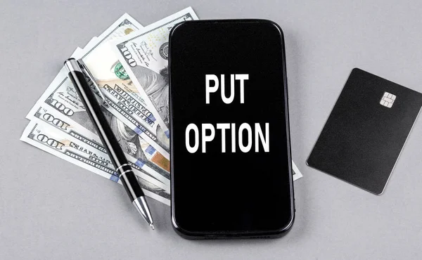 stock image Credit card and text PUT OPTION on smartphone with dollars and pen. Business