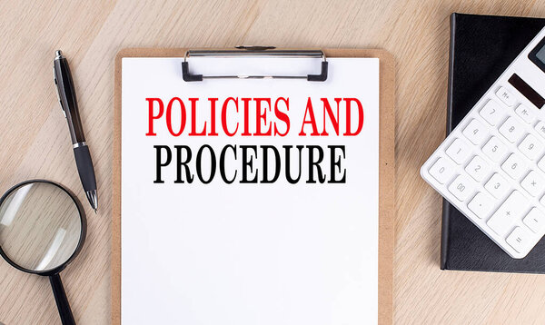 POLICIES AND PROCEDURE text on clipboard on wooden background