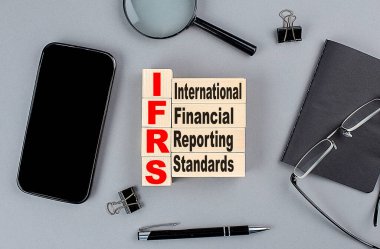 ahşap küpler IFRS wtih defter, büyüteç ve akıllı telefon, iş