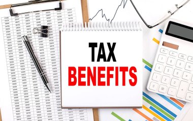 Çizelgesi, hesap makinesi ve kalemi olan bir defter üzerindeki Vergi BENEFITS metni