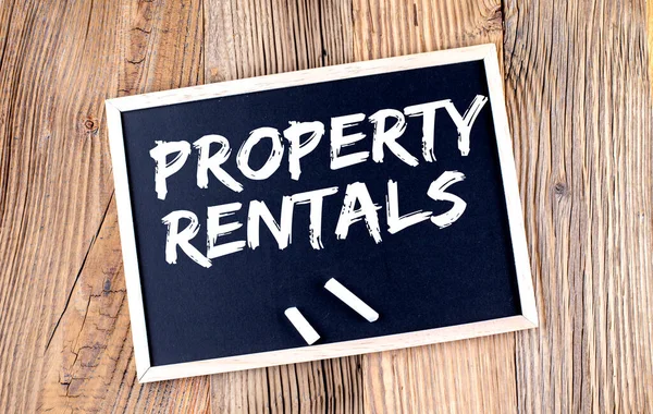 PROPERTY RENTALS text on chalkboard on the wooden background