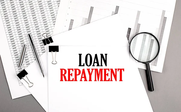 LOAN REPAYMENT text on a paper on chart background