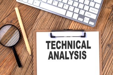 Tahta zemin üzerinde büyüteç ve klavye olan bir kağıt pano üzerinde TECHNICAL ANALYSIS metin