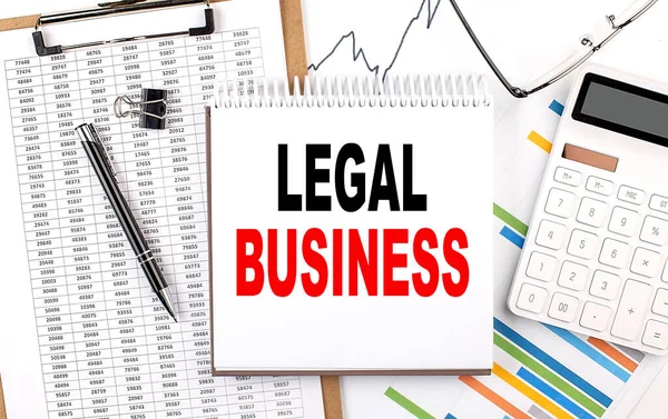 LEGAL BUSINESS text on a notebook with chart, calculator and pen