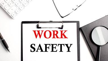 Ofis araçlarıyla birlikte bir kağıt panoya yazılmış çalışma güvenliği metni