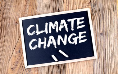 CLIMATE CHANGE text on chalkboard on the wooden background