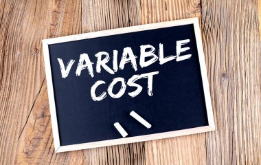 VARIABLE COST text on chalkboard on the wooden background