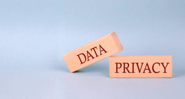 DATA PRIVACY text on wooden block, blue background