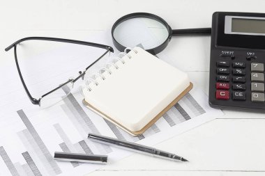 Office workplace table with calculator , chart and notebook.Top view. Copy space
