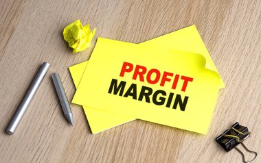 PROFIT MARGIN written on sticky on notebooks