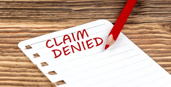 stock image Word CLAIM DENIED on paper with ped pencil on wooden background