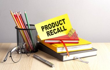 PRODUCT RECALL written on sticky on notebooks