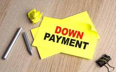 DOWN PAYMENT written on sticky on notebooks