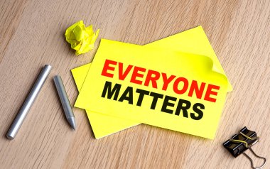 EVERYONE MATTERS written on sticky on notebooks clipart