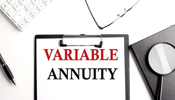 VARIABLE ANNUITY text written on a paper clipboard with office tools