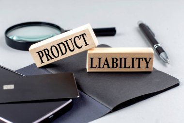 PRODUCT LIABILITY text on a wooden block on black notebook , business concept