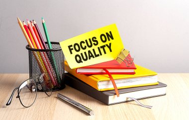 FOCUS ON QUALITY written on sticky on notebooks