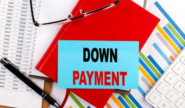 DOWN PAYMENT text on a sticky on red notebook on chart background