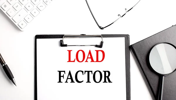 LOAD FACTOR text written on a paper clipboard with office tools