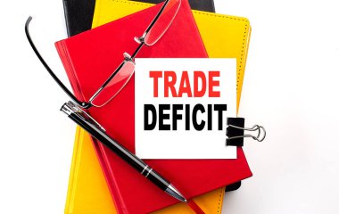 TRADE DEFICIT text written on sticky on colorful notebooks