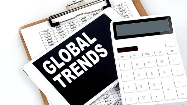 GLOBAL TRENDS text on tablet with chart, calculator and pen