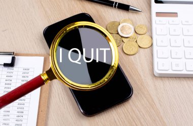 I QUIT text on magnifier with smartphone, calculator and coins