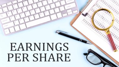 EPS - Earnings Per Share text on a blue background with keyboard and clipboard, business concept