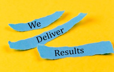 WE DELIVER RESULTS text on blue pieces of paper on yellow background, business concept