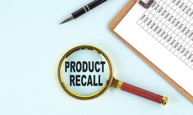 PRODUCT RECALL text on a magnifier with clipboard on blue background