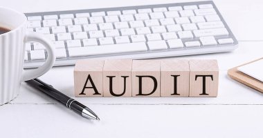 AUDIT word on wooden blocks with keyboard and coffee