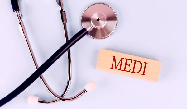Auf Blauem Hintergrund Stethoskop Und Holzblock Mit Dem Wort Medi — Stockfoto