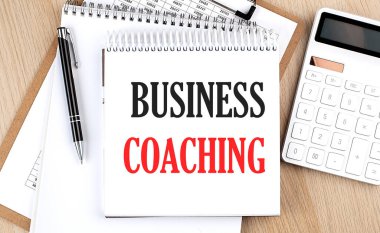 İŞ COACHING bir hesap makinesi, not panosu ve kalemin yanında beyaz not defteriyle yazılır. İş dünyası