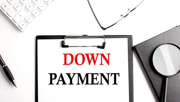 DOWN PAYMENT text written on a paper clipboard with office tools