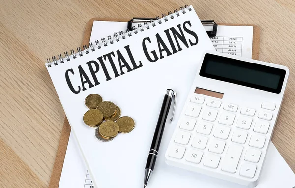 CAPITAL GAINS text with chart and calculator and coins , business