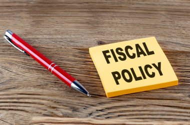 Ahşap arkaplanda kalem olan yapışkan bir yapışkan üzerindeki FISCAL POLICY metni